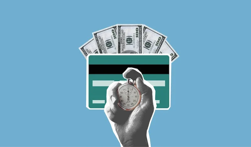 A hand holding a clock and money in front of a credit card.