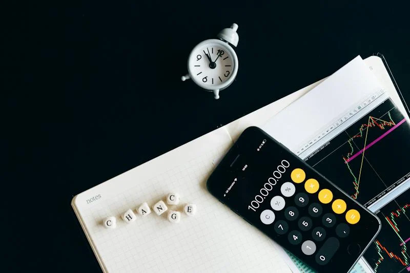 A calculator and some dice on top of a book.