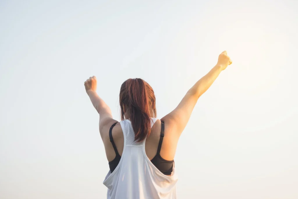 A woman with her arms raised in the air.