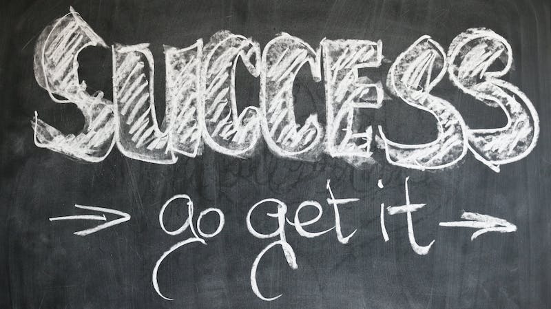 A chalkboard with the word success written in chalk.