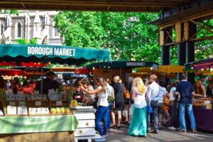 A group of people standing around at an outdoor market.