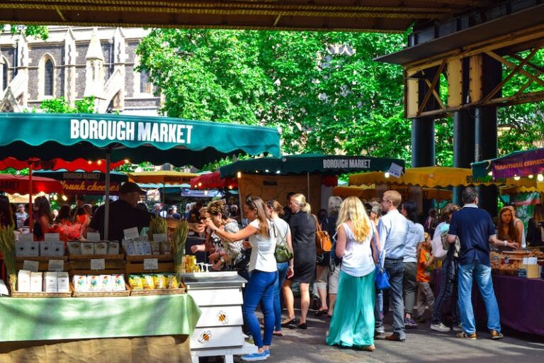 A group of people standing around at an outdoor market.