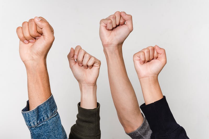 Four people with their hands up in the air.