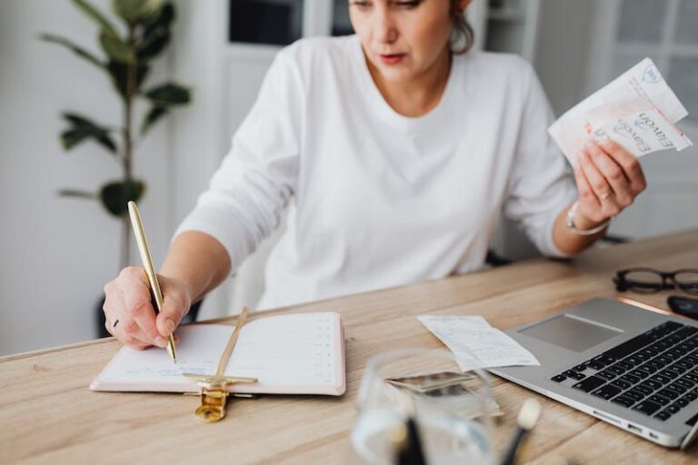 A woman writing on paper at a table.