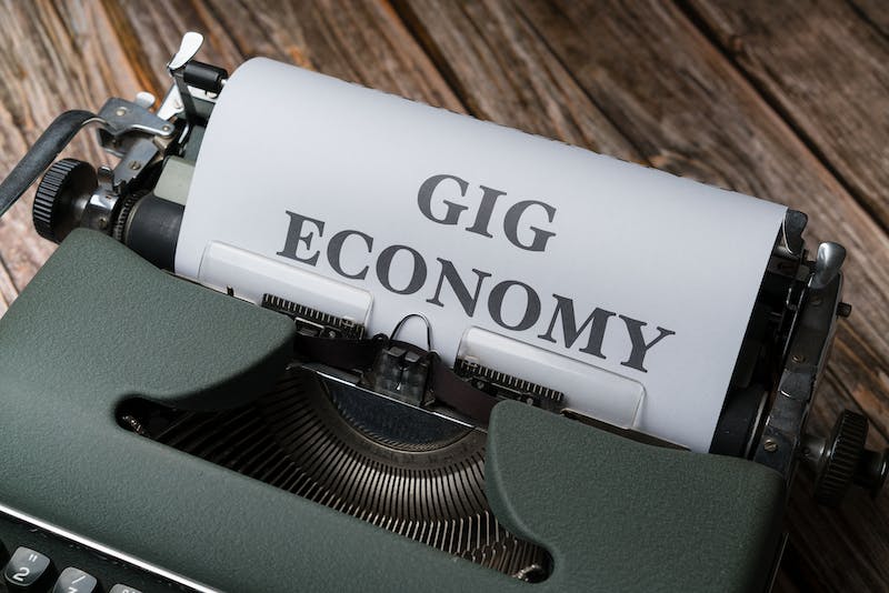 A close up of an old typewriter with the words gig economy on it