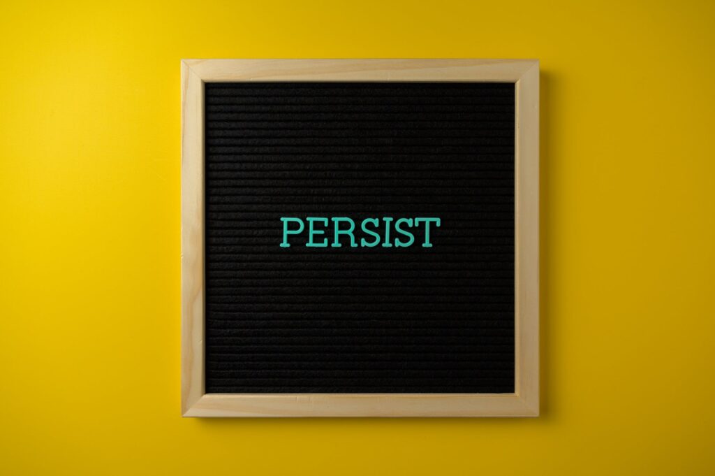 A black board with the word persist written in it.