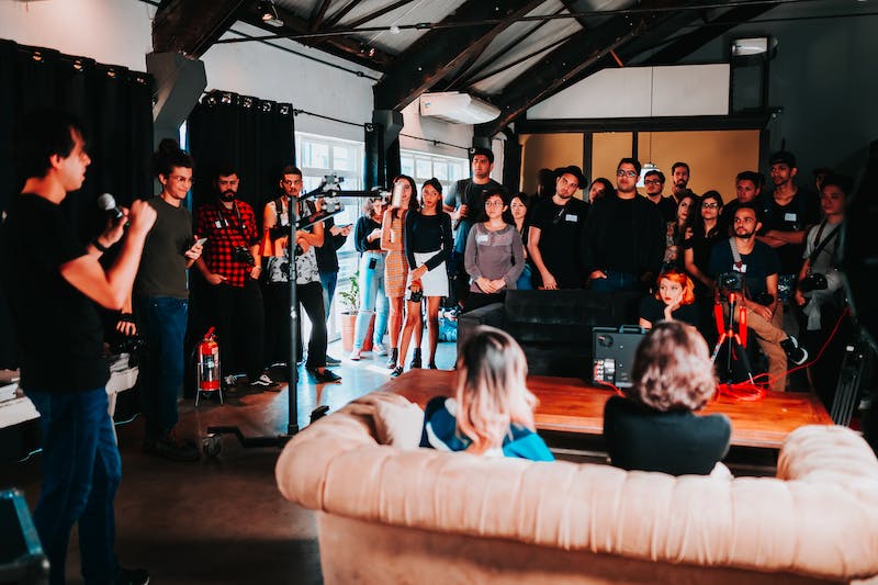 A group of people standing around in a room.