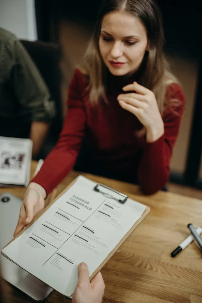 A woman sitting at a table with papers on it.