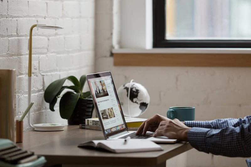 A person sitting at a desk with a laptop.