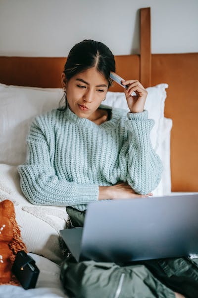 A woman sitting in bed with her laptop.