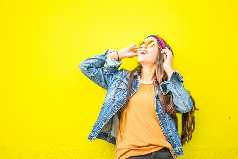 A woman wearing sunglasses and a jean jacket.