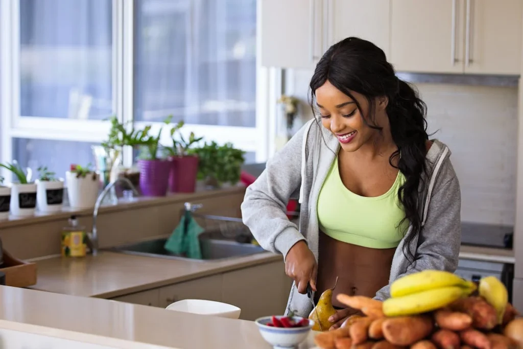 A woman cutting fruit in the kitchen