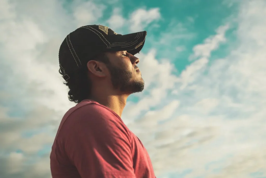 A man with a hat looking up at the sky