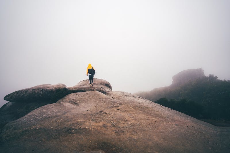 A person standing on top of a rock.